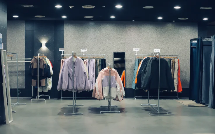 Ski wear rental room with size-labeled racks of stylish INSTAY jackets and pants.