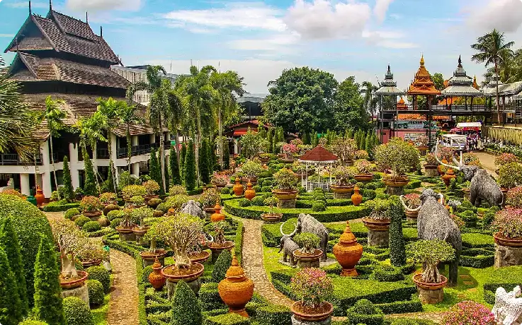 Lush tropical gardens with palm trees and colorful flowers at Nong Nooch Garden, Pattaya