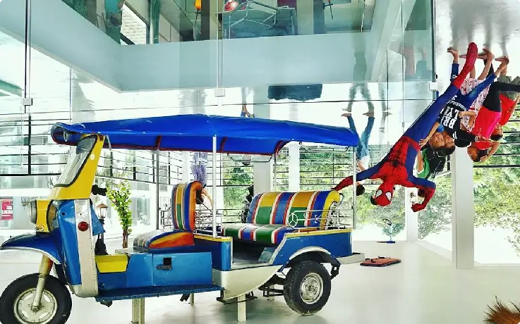 Visitors posing inside Phuket’s Upside Down House with inverted furniture and décor 3