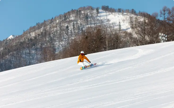 Snowboarder gliding down a snowy slope at Furano Ski Resort