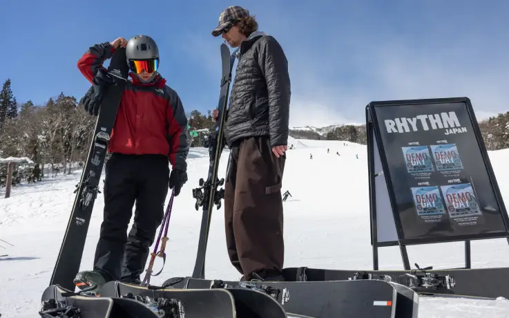 Two skiers in ski apparel from Rhythm Wadano Hakuba ski rental shop.