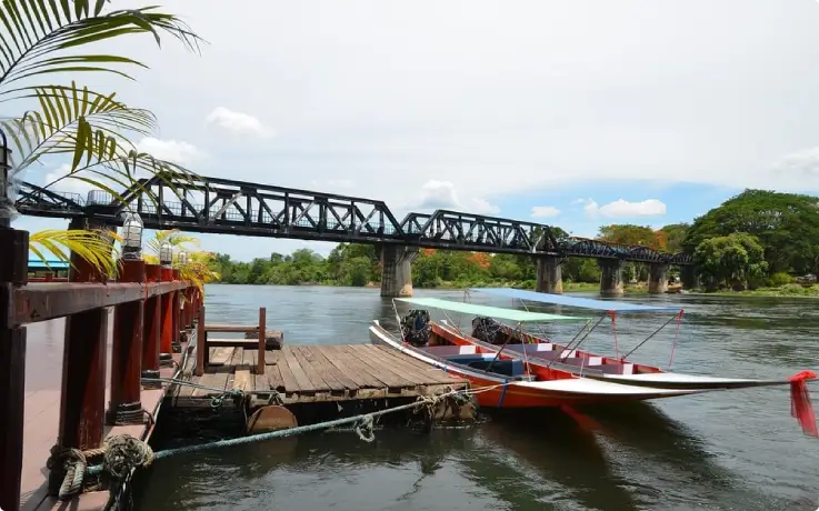 River Kwai cruise boat passing through scenic riverside landscape