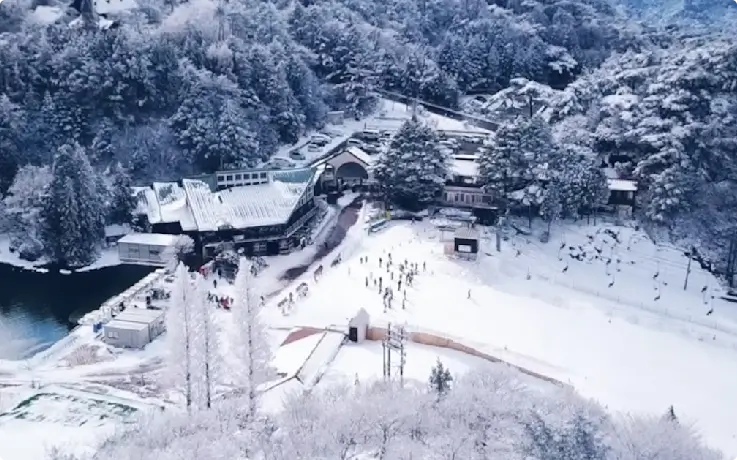 Panoramic view of Mt. Rokko Snow Park with snowy mountains and ski slopes.
